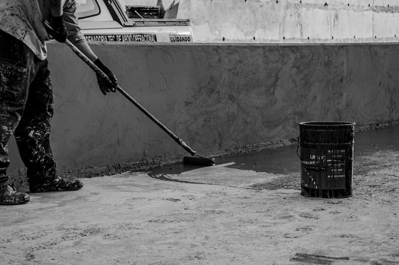 concrete sealer being applied to driveway with roller applicator