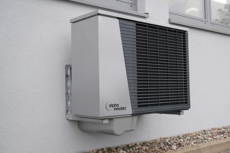 heat pump outdoor unit installed beside a house