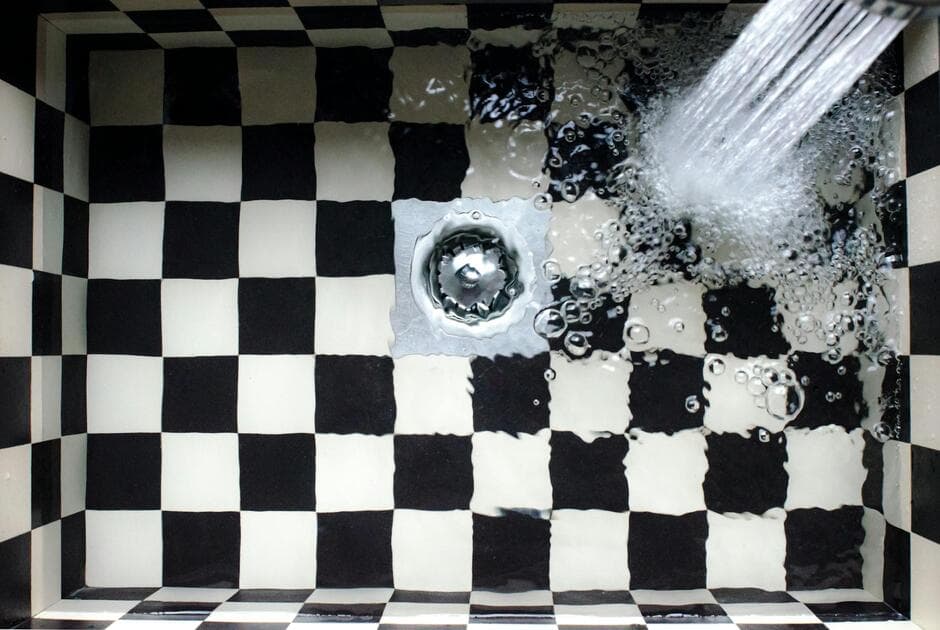 plumber using drain snake to clear a clog